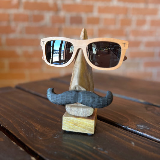 A pair of cherry wood sunglasses with a distinctive wood grain pattern, displayed on a wooden stand.