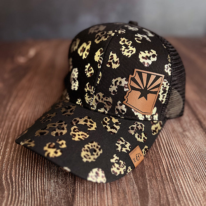 A black and gold leopard print ponytail hat with an etched patch featuring the state cutout and flag of Arizona.