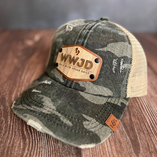 A camo ponytail hat with a wood veneer and leather patch featuring the WWJD (Walk with Jesus Daily) design.