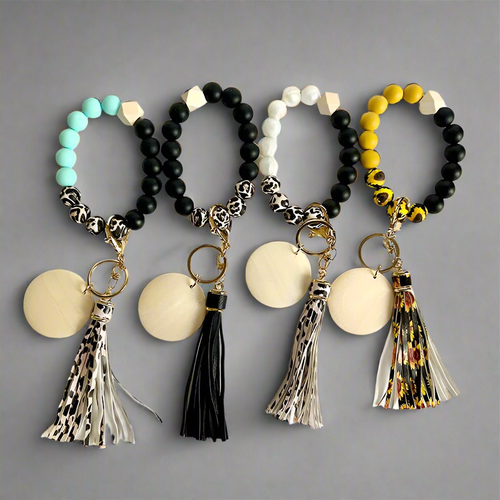 A variety of beaded wristlets and keychains in different colors and patterns, featuring silicone bands and metal accents.