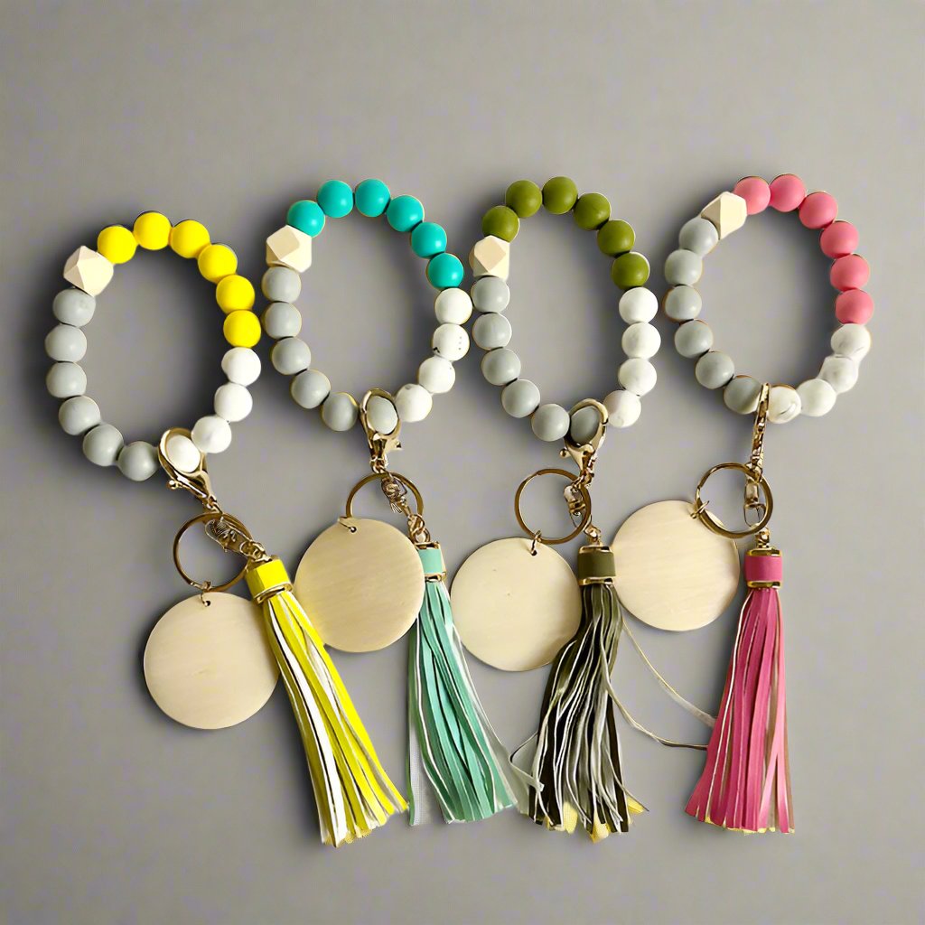 A series of four silicone wristlets, each adorned with a different color bead, and four matching etched keychains with different colored beads.