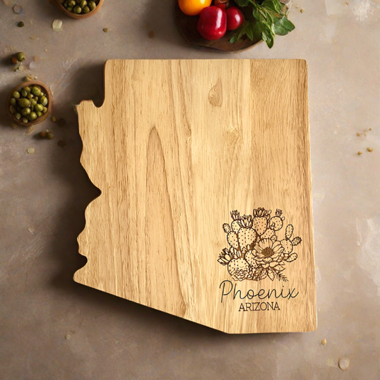 An Arizona-shaped wood charcuterie board with a city name engraving, placed on a kitchen counter.