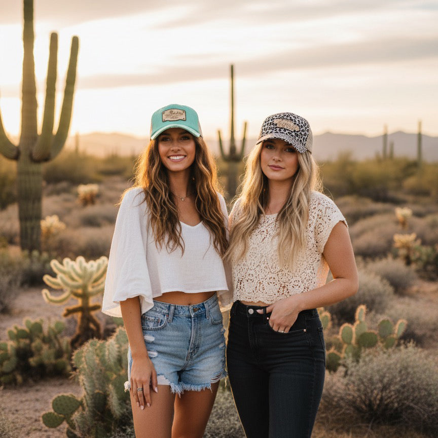 Two women standing in a desert landscape with cacti.